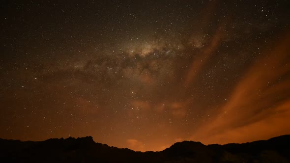 View of Milky Way glowing through thin veil of clouds passing overhead