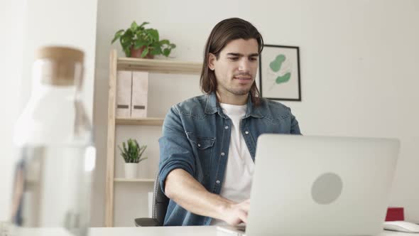 Young Freelancer Man Working on Laptop Computer From Home Office