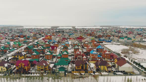 Cottage Complex with Multicolored Houses Against Snowy Field