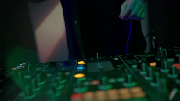 Hands of Dj Touching Buttons and Sliders Playing Electronic Music Using Mixing Controller Rocking