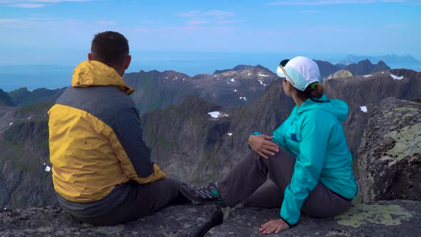 A Man and a Woman Are Sitting on Top of a Rock