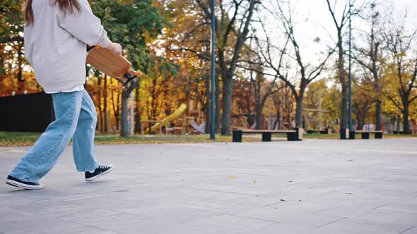 Slow Motion Side View of a Young Teenage Girl Performing Tricks While Riding a Longboard