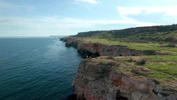 Panoramic video with mother and daughter walking along picturesque rocky coastline