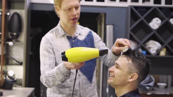 Hairdresser Dries Hair Dryer Brunette Man in a Barbershop