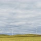 Blades of a Large Wind Turbine in a Field Against a Background of Cloudy Blue Sky on the Horizon - VideoHive Item for Sale