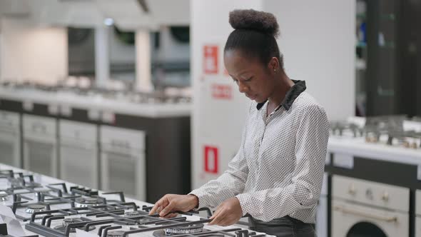 Shopping in Home Appliance Stores in Mall Young Afroamerican Woman is Viewing Exhibition Samples of