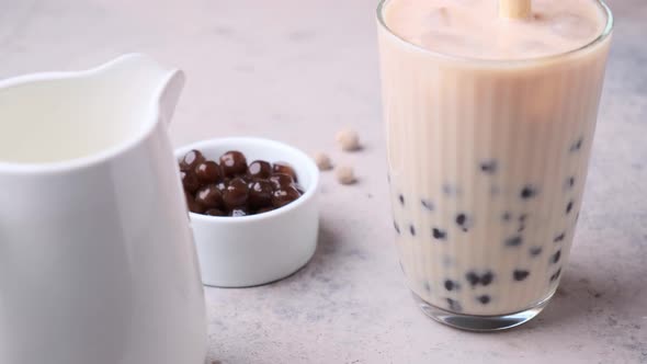 Cooking milk bubble tea with tapioca pearls in glass.