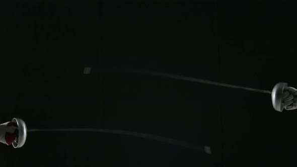 Hands of Female Fencers with Rapiers Close Up on a Black Studio Background