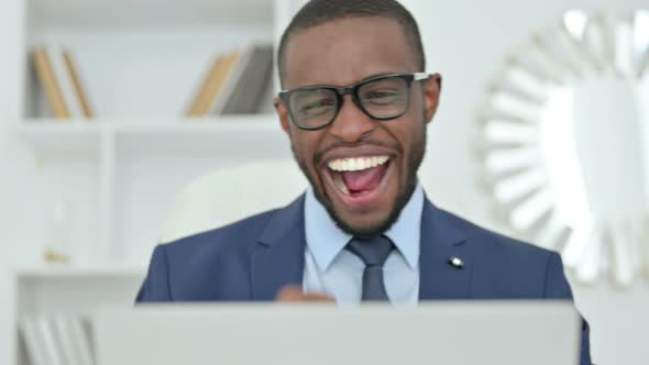 Portrait of African Businessman Celebrating Success on Laptop 