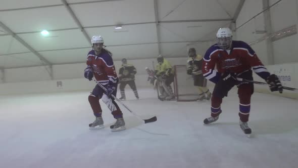 Men playing ice hockey in a skating rink.