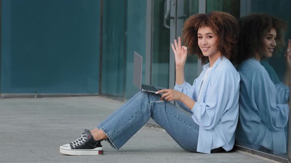 Young Curly African American Woman Student Girl Businesswoman User Sitting Outdoors Near Glass