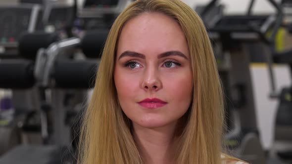 A Young Beautiful Woman Looks Around in a Gym - Face Closeup