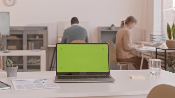 Laptop with Greenscreen in Busy Office