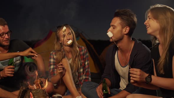 Friends Sitting By Fire Talking Eating Fried Hot Marshmallows Chatting Smilling