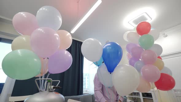 Woman Using Helium Tank Blowing Up Balloons to Decorate Home for Party Colorful Balloons for