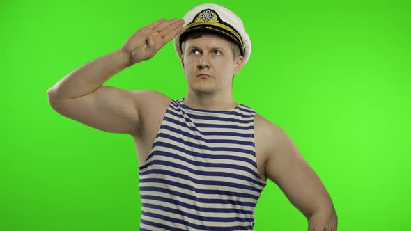 Young Sailor Man Salutes with Hand, Looking Up. Seaman Guy in Sailor's Vest
