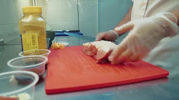 Cook Puts a Piece of Meat on Chopping Board