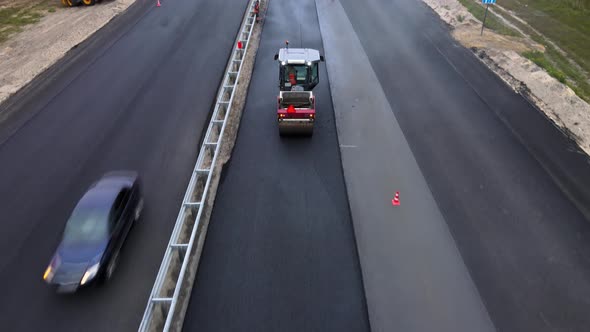 Road machinery at work. Workers lay new tarmac using roller and an asphalt paver