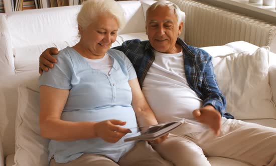 Senior couple looking at a photo album in living room