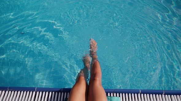 Woman on Vacation Dangling Legs in the Pool