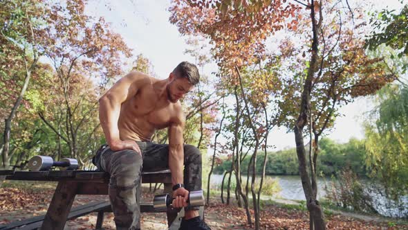 Shirtless sportsman doing workout in autumn park. 