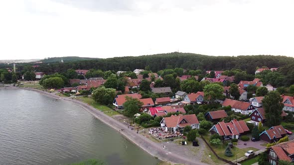 Small town of Nida and historical buildings, side aerial flying view