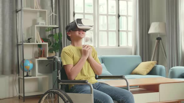 Scary Asian Kid Girl Sitting In A Wheelchair While Wearing Virtual Reality Watching Horror Movie