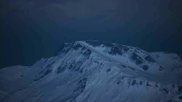 Dramatic Dark Rocky Mountain with Patches of Snow in Storm