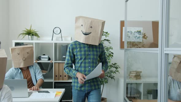 Businesspeople with Paper Bags on Heads Showing Emoji Busy with Paperwork in Office