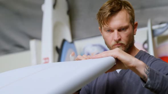 Man examining a surfboard