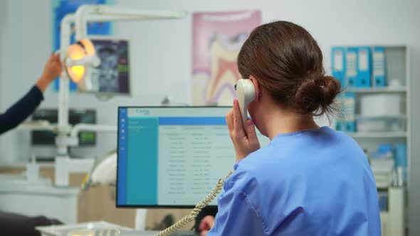 Orthodontist Nurse Talking at Phone Making Dental Appointments