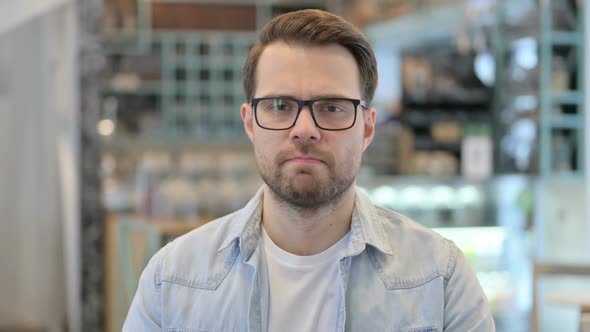 Young Man Feeling Sad in Cafe