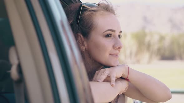 Pretty Lady Leans Out of Car and Greets Friend at Farmland