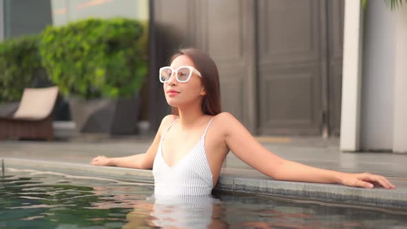 Young asian woman enjoy around outdoor swimming pool for leisure