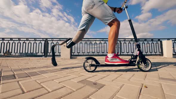 Side View of a Disabled Man Riding a Scooter in Slow Motion