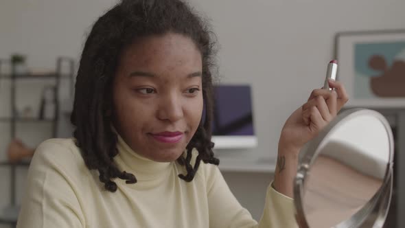 Young African Woman Applying Beautiful Lipstick