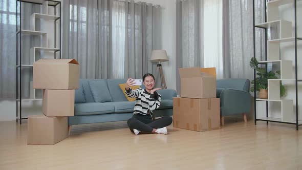 Asian Woman With Cardboard Boxes Taking Photo By Smartphone After Moving Into A New House 