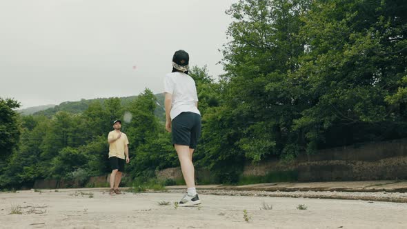 A Caucasian young couple, a woman and a man, playing at badminton. Low angle view. Summer recreation