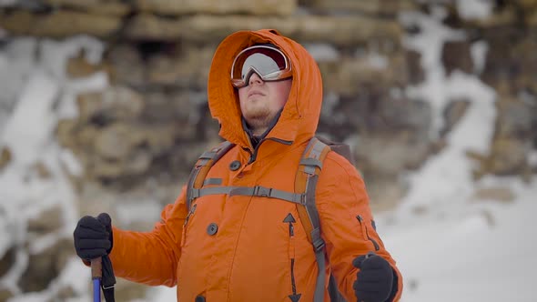 Male Rock Climber Is Wearing Sunglasses Is Standing in Mountains in Winter Day