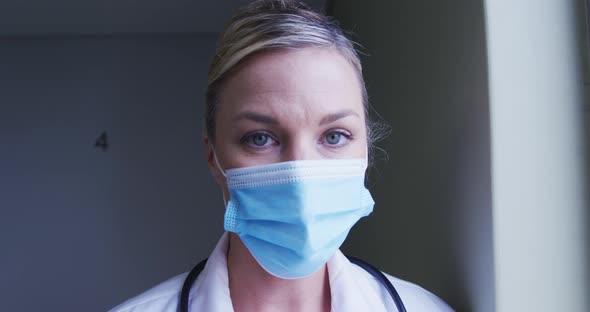 Portrait of caucasian female doctor wearing face mask at hospital