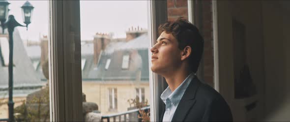 Young man daydreaming by the window