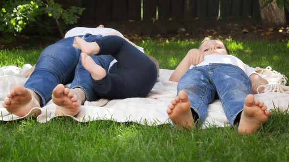 Closeup of Children and Mothers Feet Lying on Grass in Park or Garden