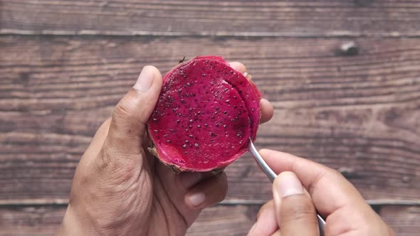 Young Man Eating Dragon Fruit Top View