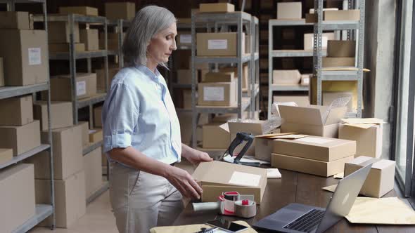 Female Warehouse Worker Packing Ecommerce Parcel Shipping Box