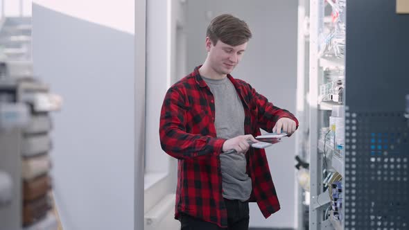 Positive Young Man Imitating Kung Fu Posture Posing with Putty Knives in Hardware Store