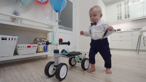 Kid on Baby Bicycle Balance Bike for Toddlers with Colorful Balloons 1 Year Old Baby Boy Celebrating