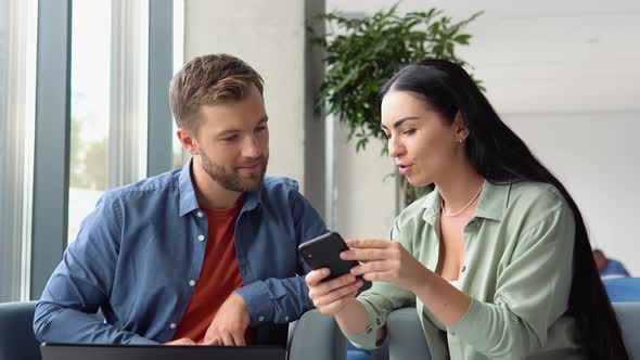 Motivated Diverse Colleagues Look at Laptop Screen Discuss Business Project Ideas Together