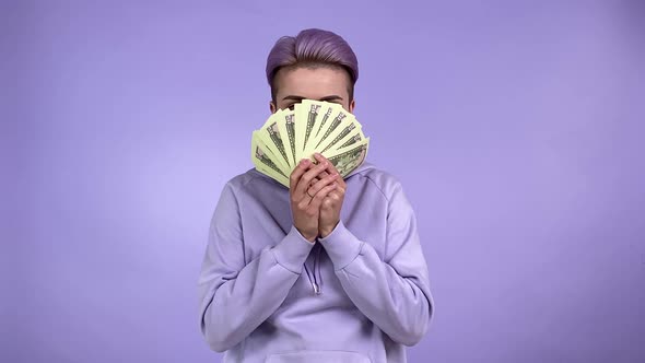 Young Woman Hiding Bunch of Banknotes Lowering Money Smiling Indoors