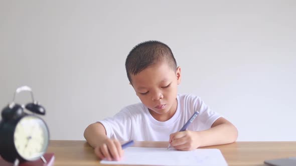 boy sitting and doing homework, drawing, coloring