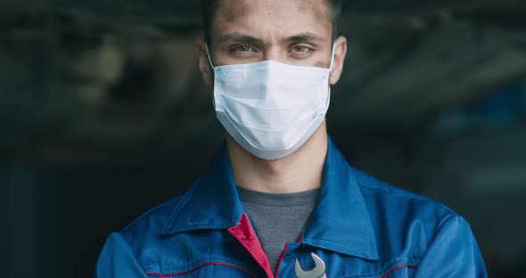 Close Up Portrait of Tired and Dirty Auto Mechanic Wearing Protective Medical Mask